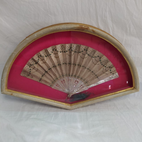 Ventaglio panna con decorazione verde e paiettes, sfondo fucsia. Vetro rotto