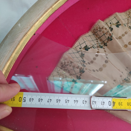 Ventaglio panna con decorazione verde e paiettes, sfondo fucsia. Vetro rotto