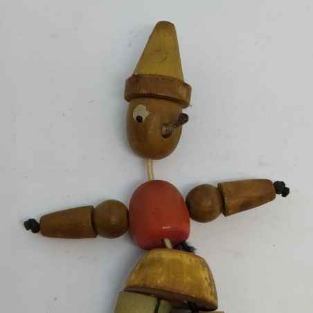 Pinocchio in legno snodato con anima in elastico. Colori sbiaditi e macchie