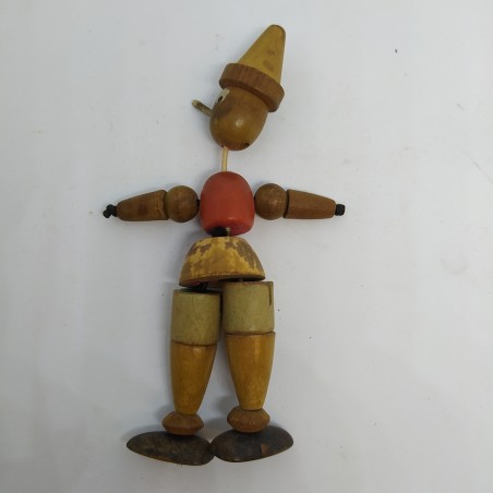 Pinocchio in legno snodato con anima in elastico. Colori sbiaditi e macchie