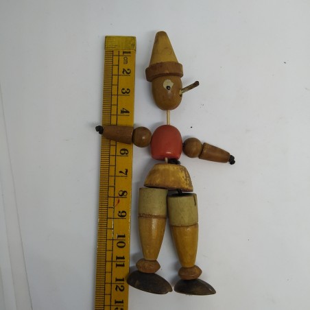 Pinocchio in legno snodato con anima in elastico. Colori sbiaditi e macchie