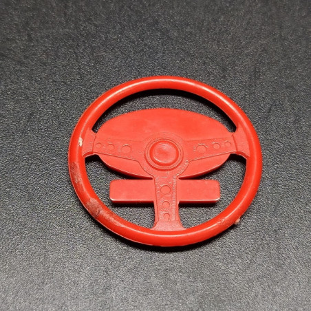 Fregio Innocenti in plastica rossa con dettagli dorati. Segni sul retro
