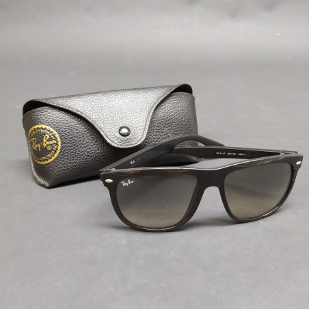 Occhiali da sole Ray-Ban con montatura nera in plastica, segni sulle lenti