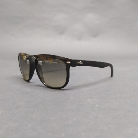 Occhiali da sole Ray-Ban con montatura nera in plastica, segni sulle lenti
