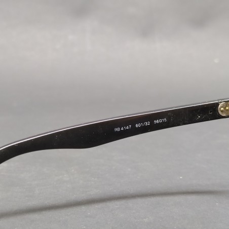 Occhiali da sole Ray-Ban con montatura nera in plastica, segni sulle lenti