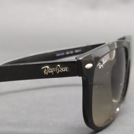 Occhiali da sole Ray-Ban con montatura nera in plastica, segni sulle lenti