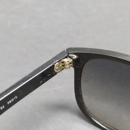 Occhiali da sole Ray-Ban con montatura nera in plastica, segni sulle lenti