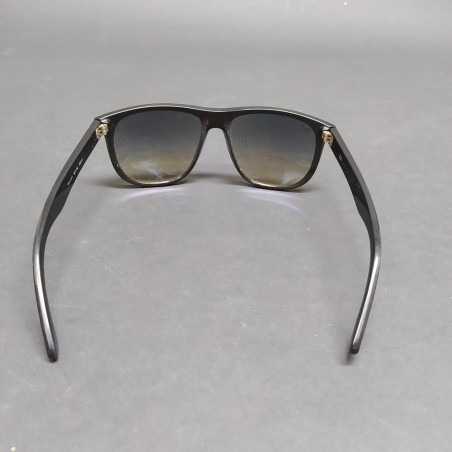 Occhiali da sole Ray-Ban con montatura nera in plastica, segni sulle lenti